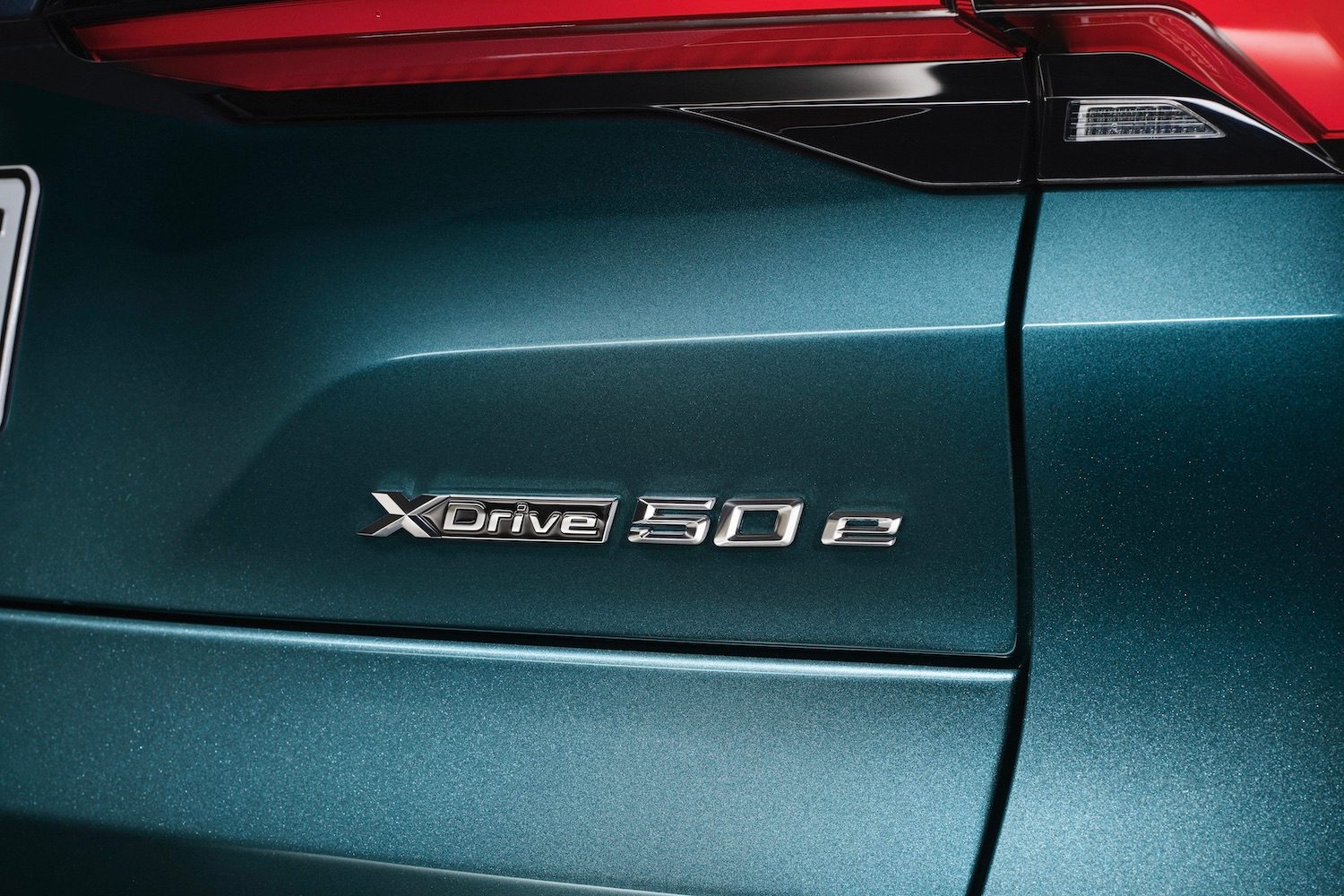 Close up of badges on the 2024 BMW X5 xDrive50e PHEV parked in a studio on the liftgate.