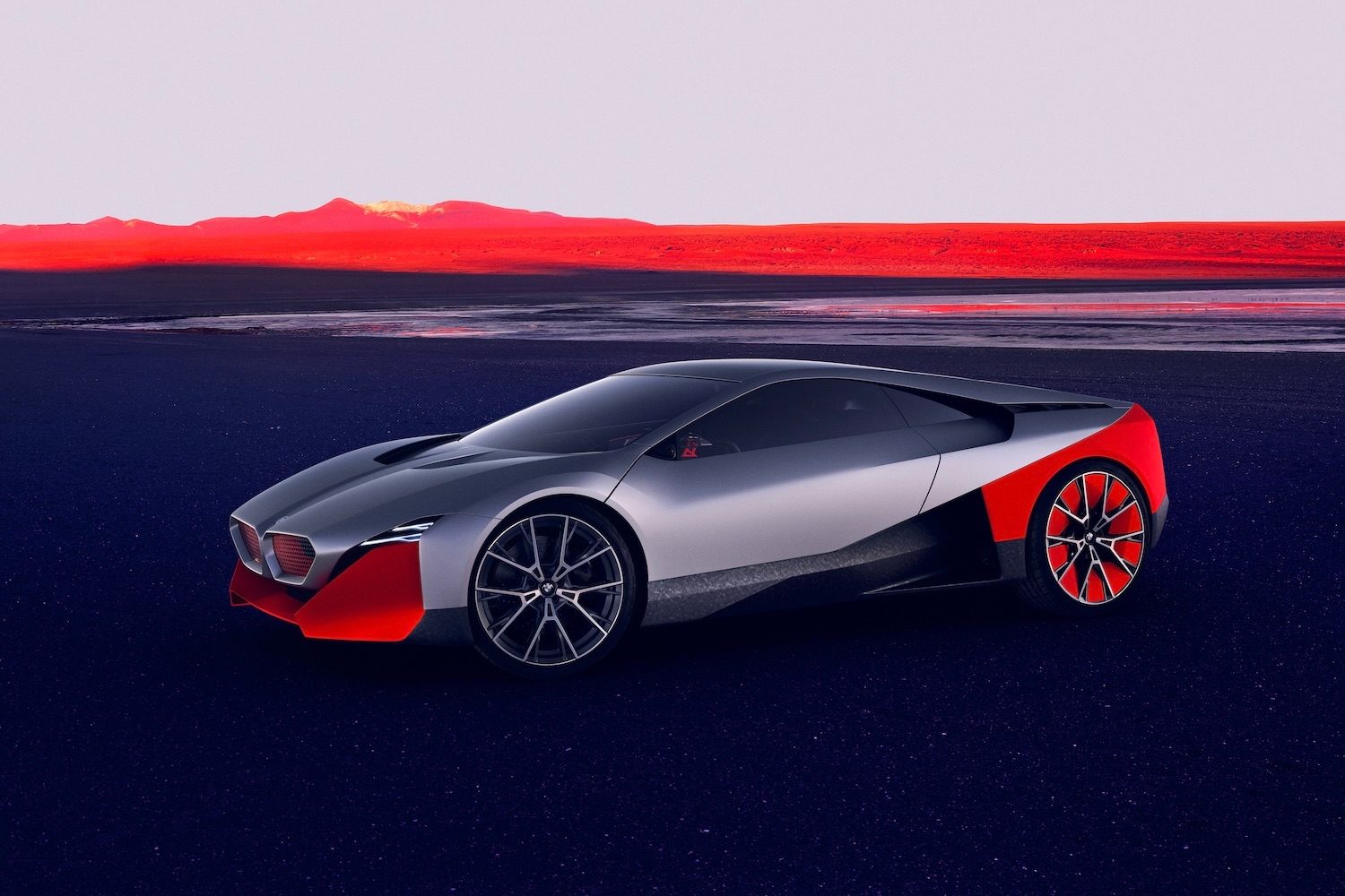 BMW M Vision NEXT Concept front end angle from driver's side in front of red mountains.