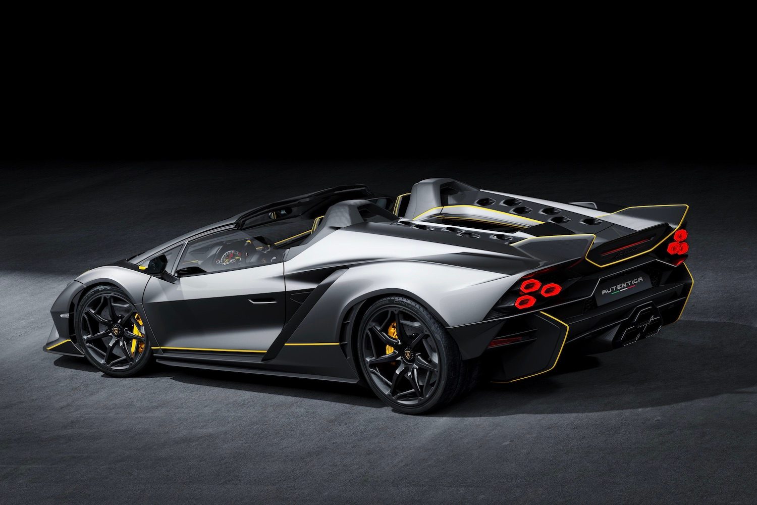 Rear end angle of Lamborghini Aut&eacute;ntica from driver's side in a dark studio with studio lighting.