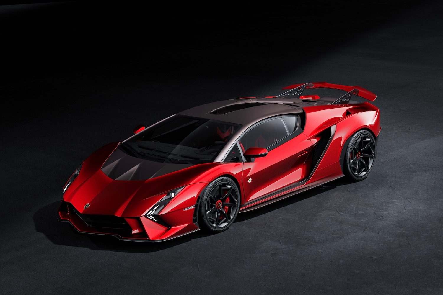 Front end angle of Lamborghini Invencible from driver's side in a dark studio with studio lighting.