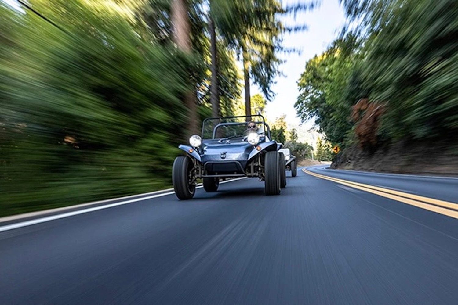 Meyers Manx Remastered Kit driving down the road with trees in the back.