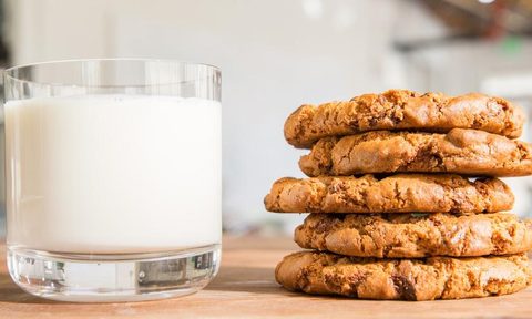 A stack of cookies with a glass of milk