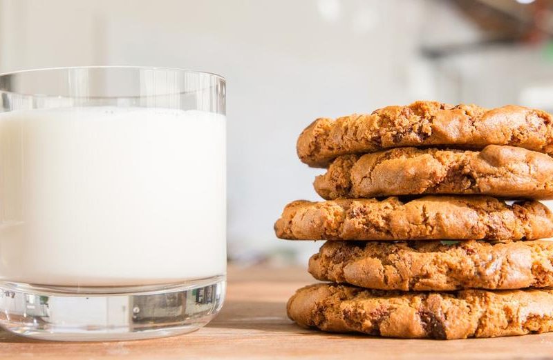 A stack of cookies with a glass of milk