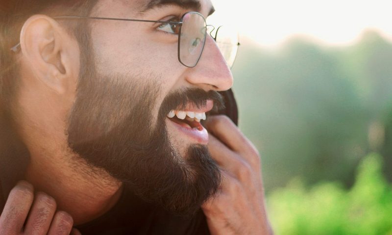 A bearded man waring glasses, smiling.