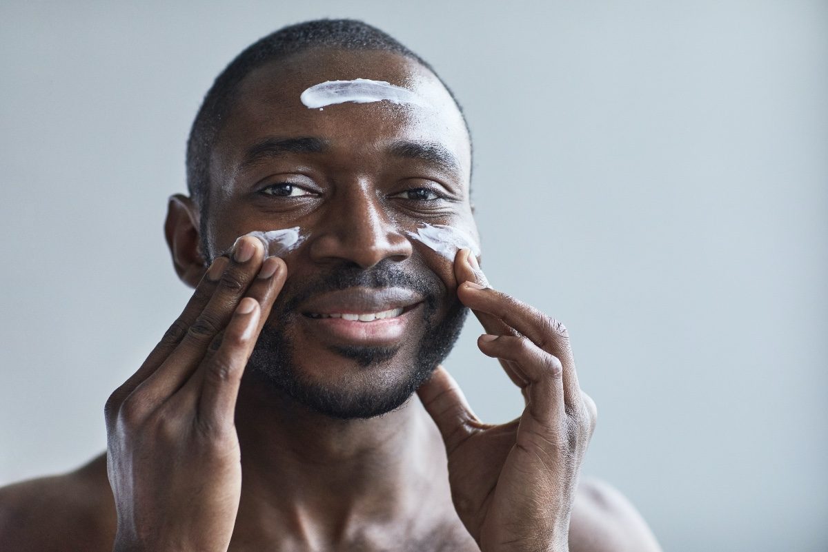 man putting on moisturizer