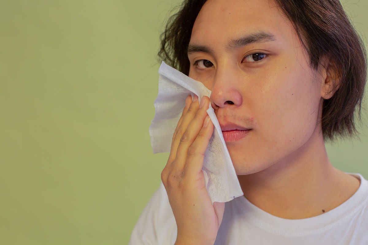 man wiping his face