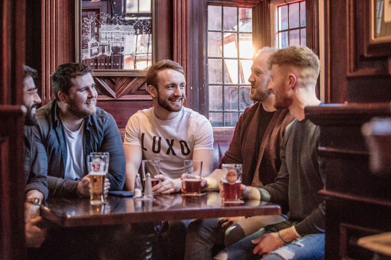 Group of men laughing and drinking at O'Neill's Pub & Kitchen in Dublin, Ireland.