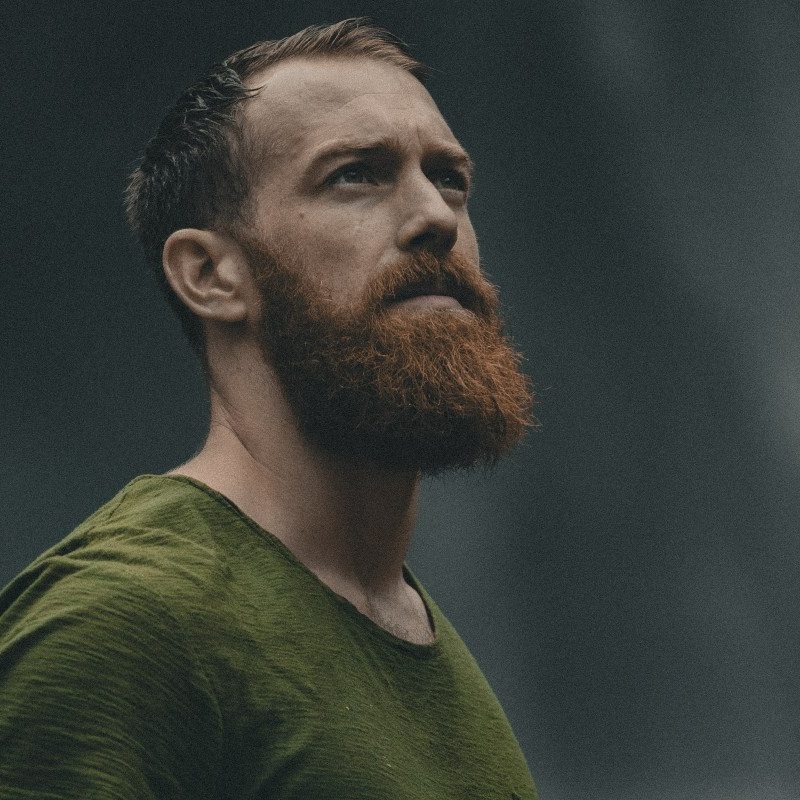 A man with a red beard and wearing a green shirt.