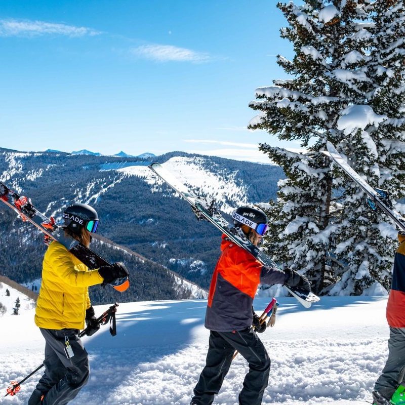 A group of friends walking in the snow to go skiing.