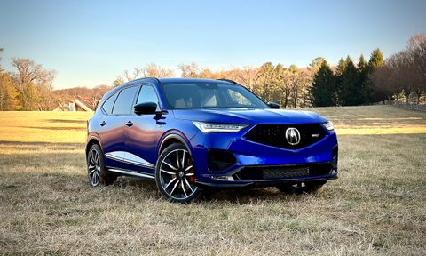 Front end angle of the 2022 Acura MDX Type S from the passenger's side in a hay field.