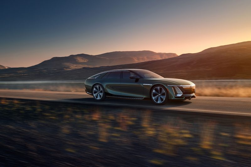 2023 Cadillac Celestiq front end angle from passenger side driving down the road in front of mountains.