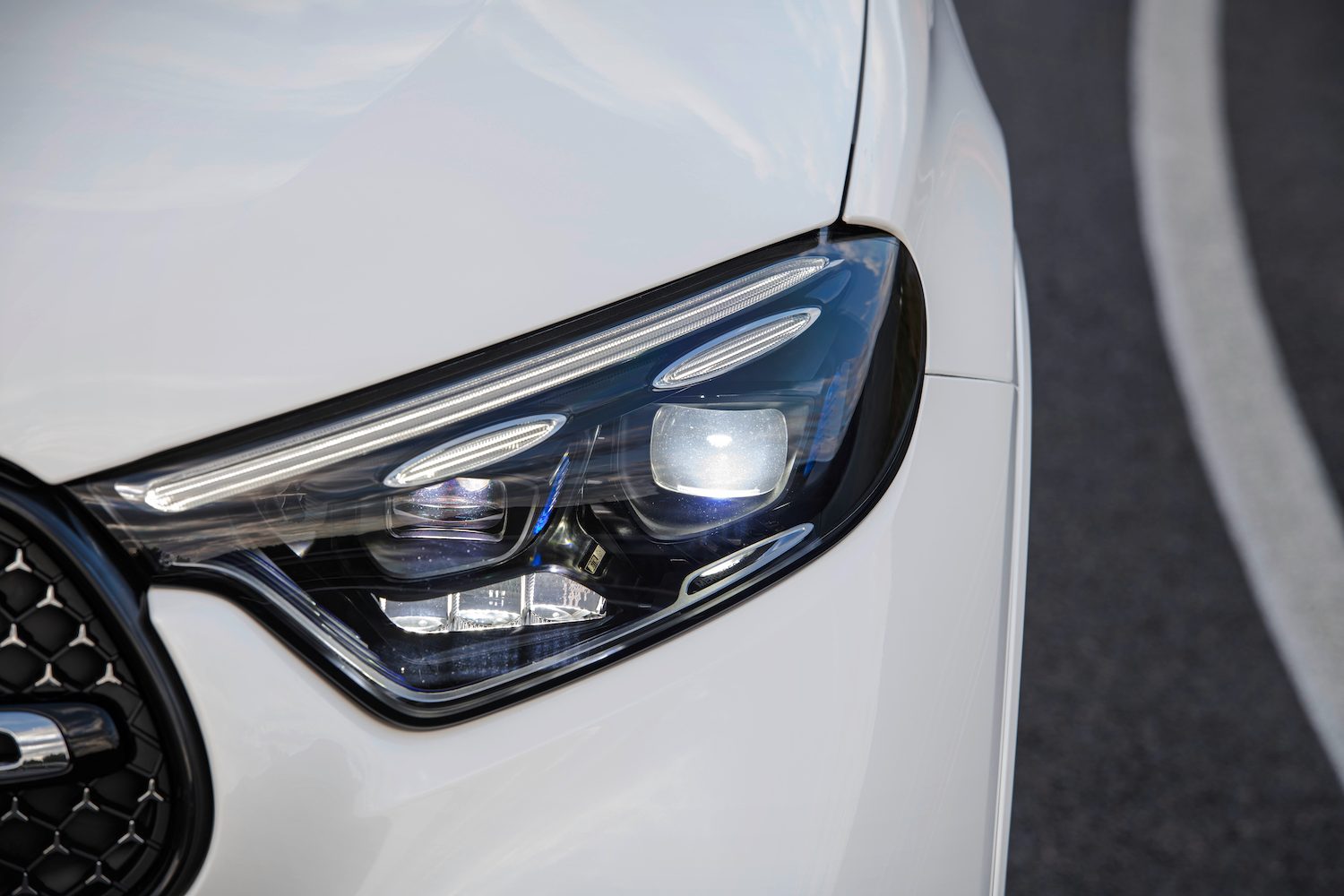 Close up of headlights on the 2023 Mercedes-Benz GLC parked on a street.