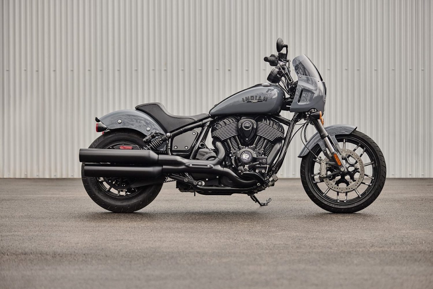 Side profile of the 2023 Indian Sport Chief parked in front of a wall on concrete.