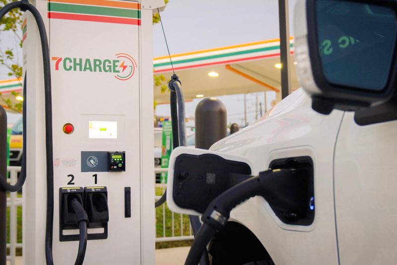 7Charge electric vehicle charging station by 7-Eleven with an EV charging at a convenience store.
