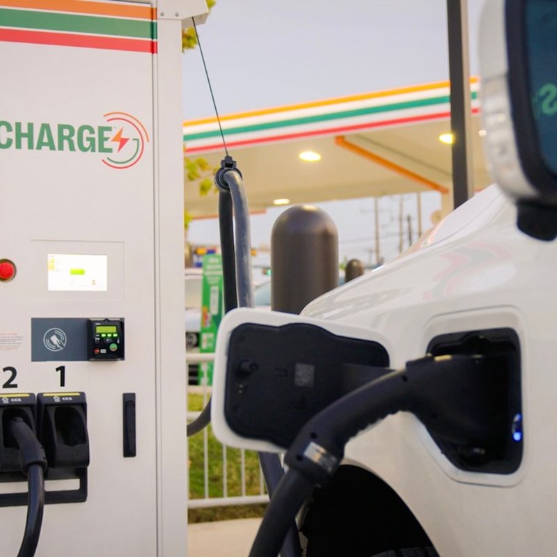 7Charge electric vehicle charging station by 7-Eleven with an EV charging at a convenience store