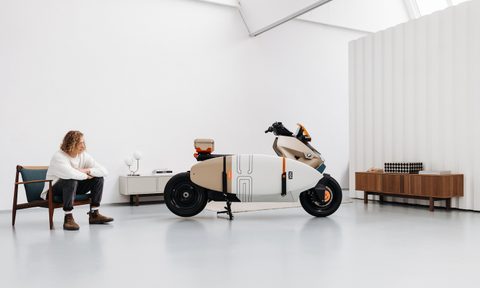 BMW CE 04 Vagabund Moto Concept parked in the middle of a studio with a man looking at the scooter.
