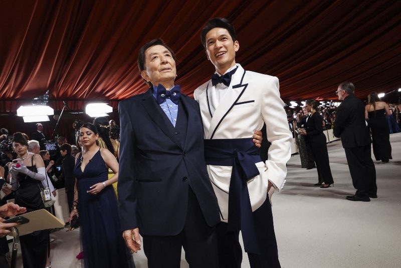 Harry Shum Jr. standing with James Hong wearing an eastern inspired tuxedo