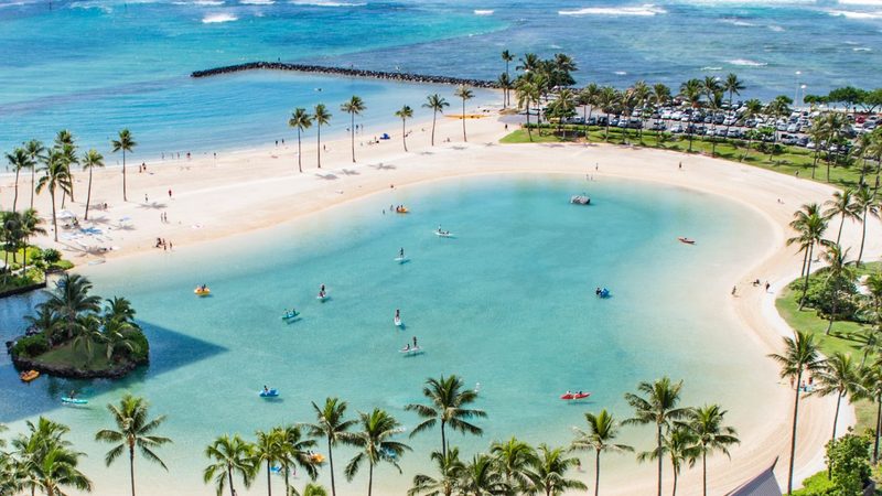 A view of the beach with people enjoying the water.
