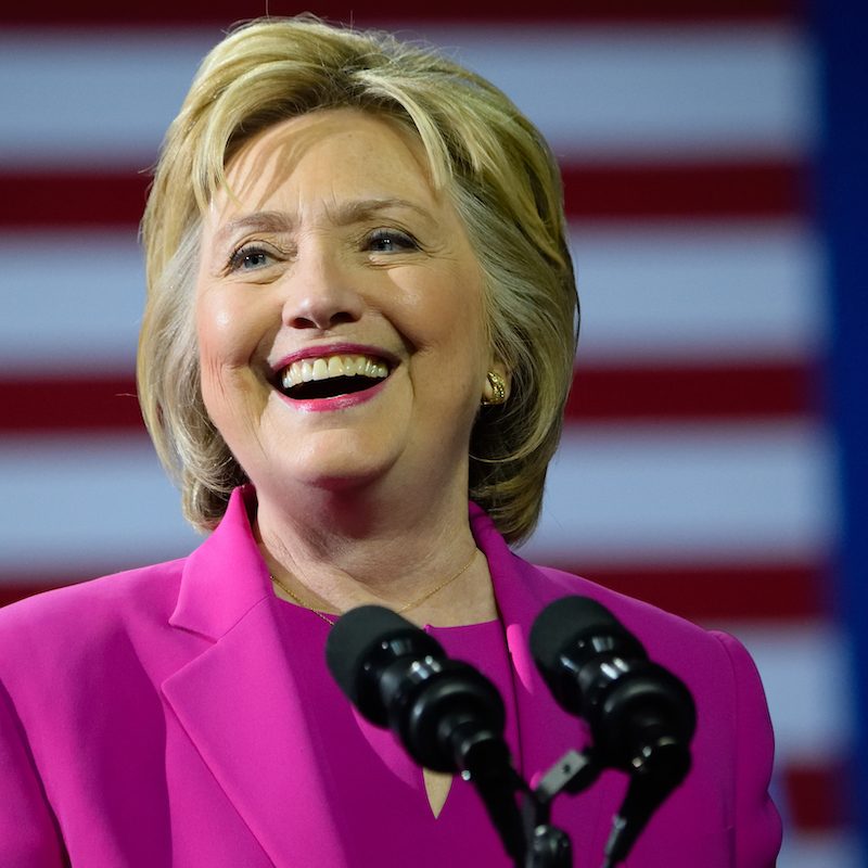 Hillary Rodham Clinton speaking with an American Flag in the background