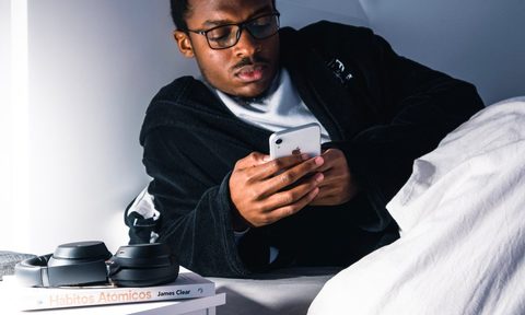 A man getting ready for bed but still on his phone.