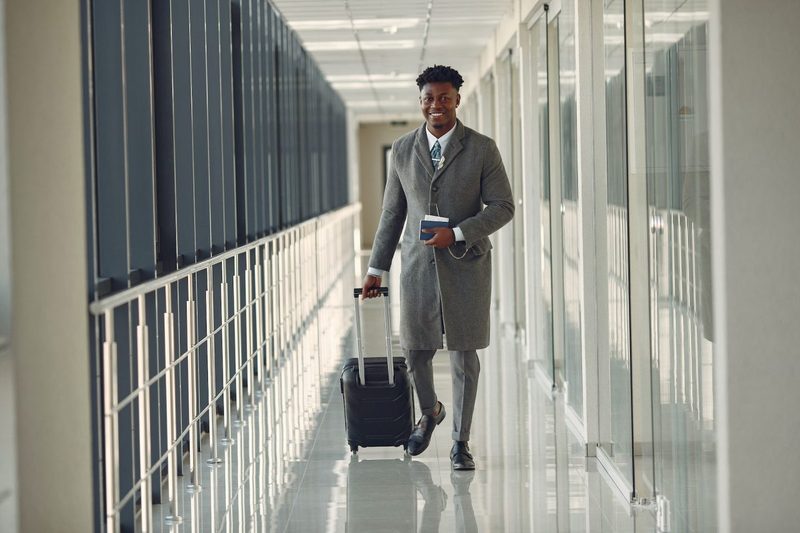 A person hauling their luggage down the hallway at an airport.