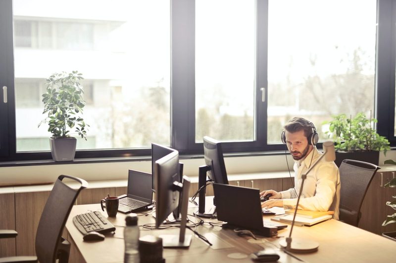 A person sitting at their desk working on the computer in an office.