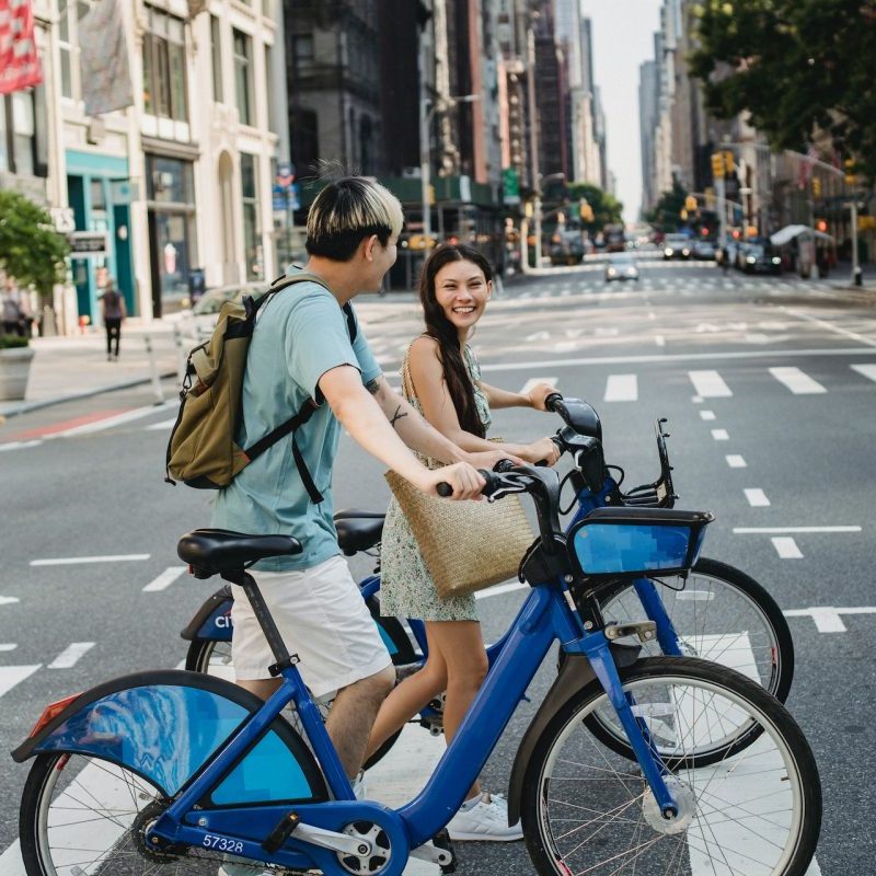 People crossing the street in the city, walking their bikes