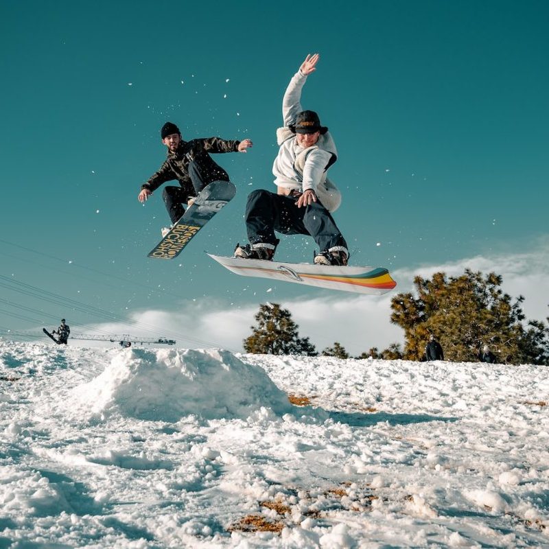 People doing jumps on snowboard in the snow.