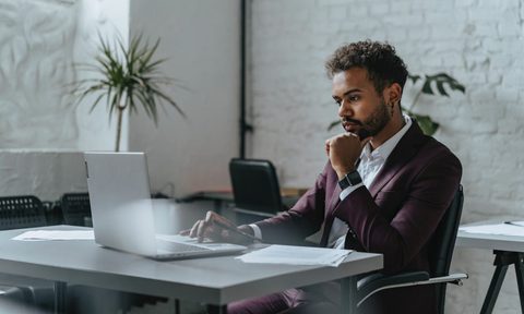 A person working alone on at a computer at a desk.