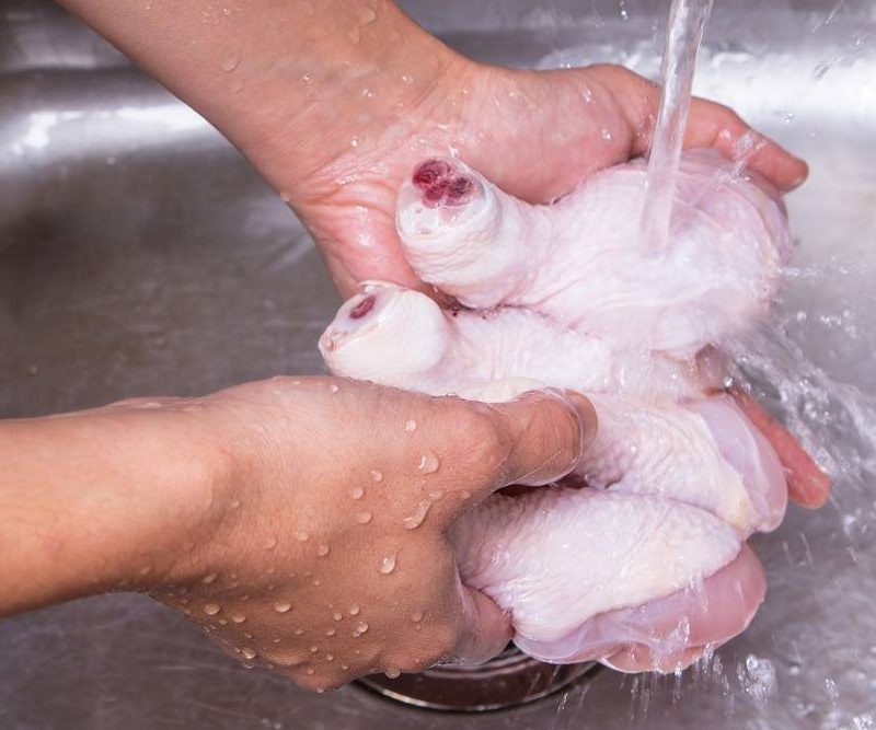Rinsing chicken in sink