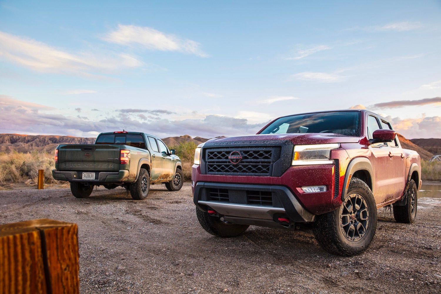 2022 Nissan Frontier Pro-4X front end and rear end angle in front of blue skies on a dirt trail