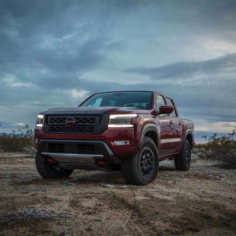 Front end angle of the 2022 Nissan Frontier Pro-4X during sunset with dark clouds in the back