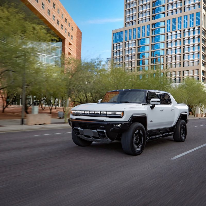 2023 GMC HUMMER EV Edition 1 Pickup front end angle driving down a busy city street.