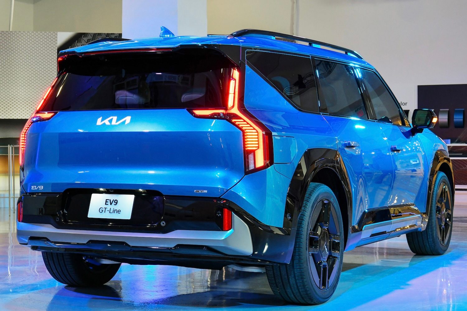 2024 Kia EV9 rear end angle with taillights on in studio.