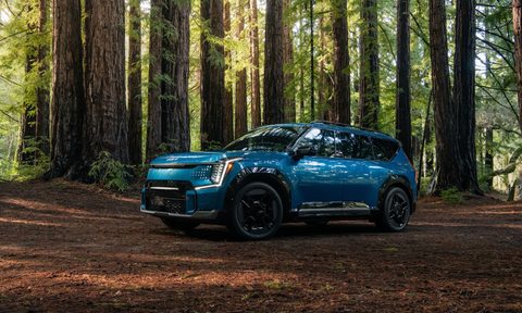 2024 Kia EV9 GT-Line parked in the woods with tall trees.