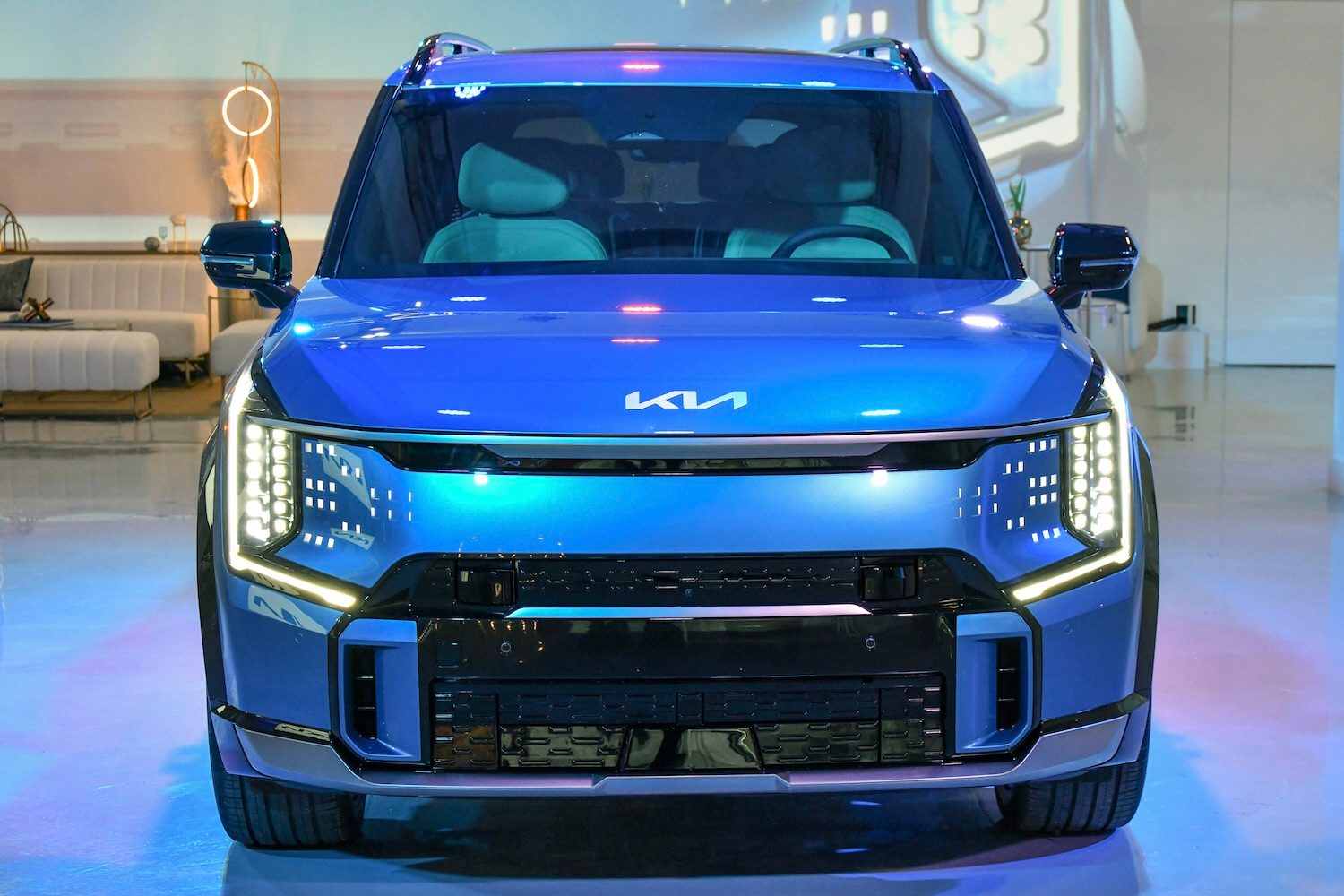 Close up of front end of the 2024 Kia EV9 with headlights on.