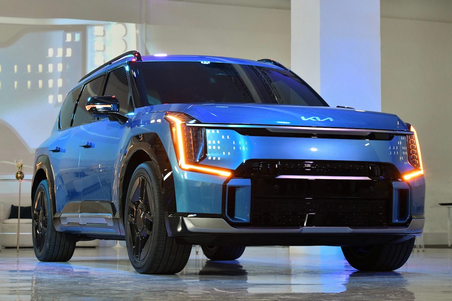 Front end angle close up of headlights on 2024 Kia EV9 in a studio.