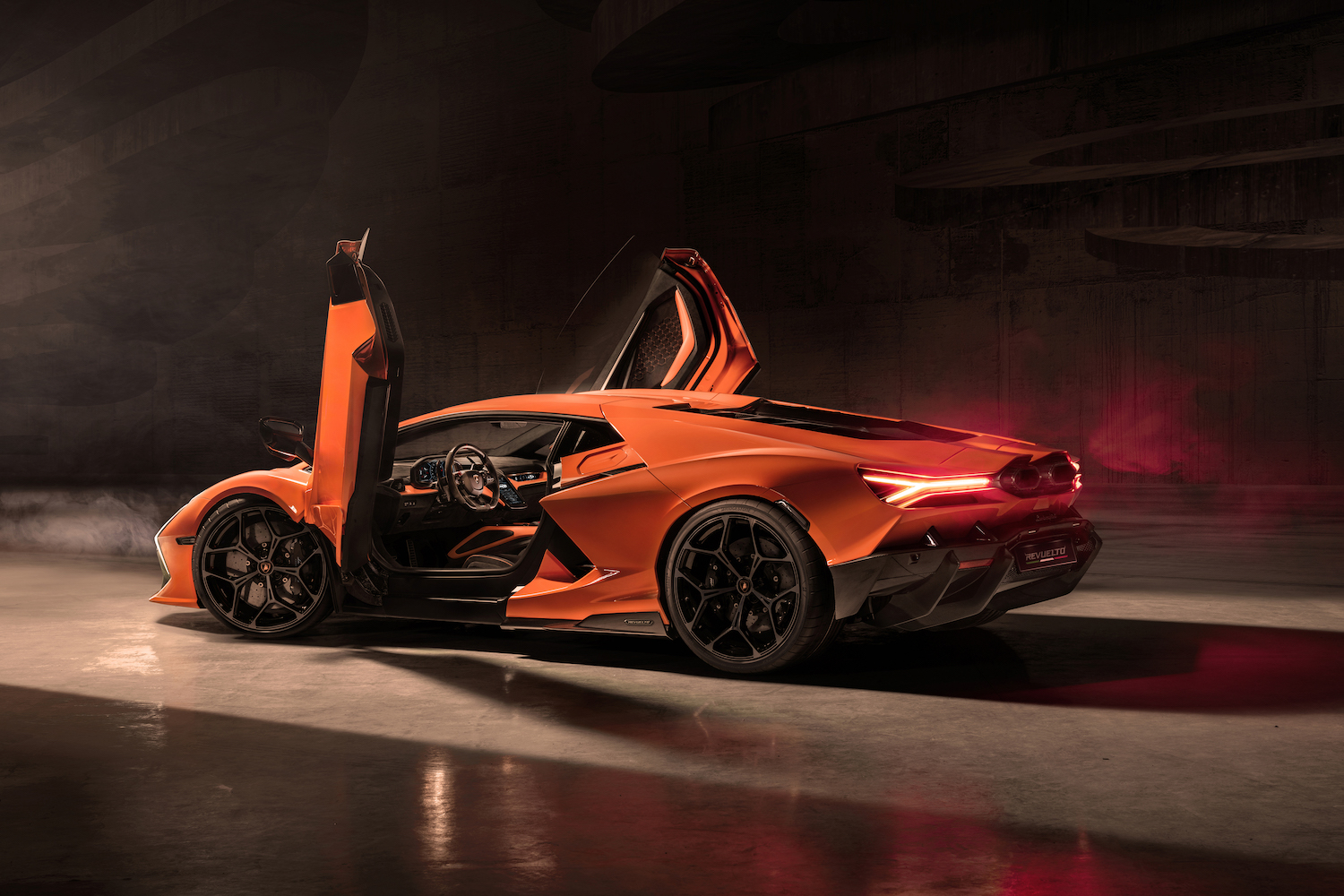 Rear end angle of the 2024 Lamborghini Revuelto with the doors up in a studio.