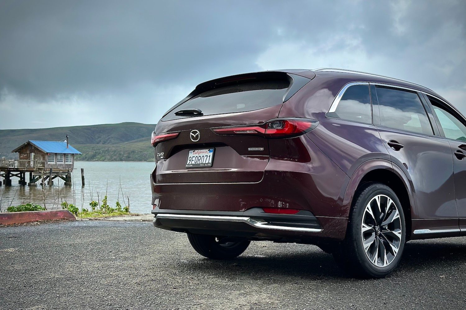 Close up of rear end of the 2024 Mazda CX-90 parked in front of a lake.