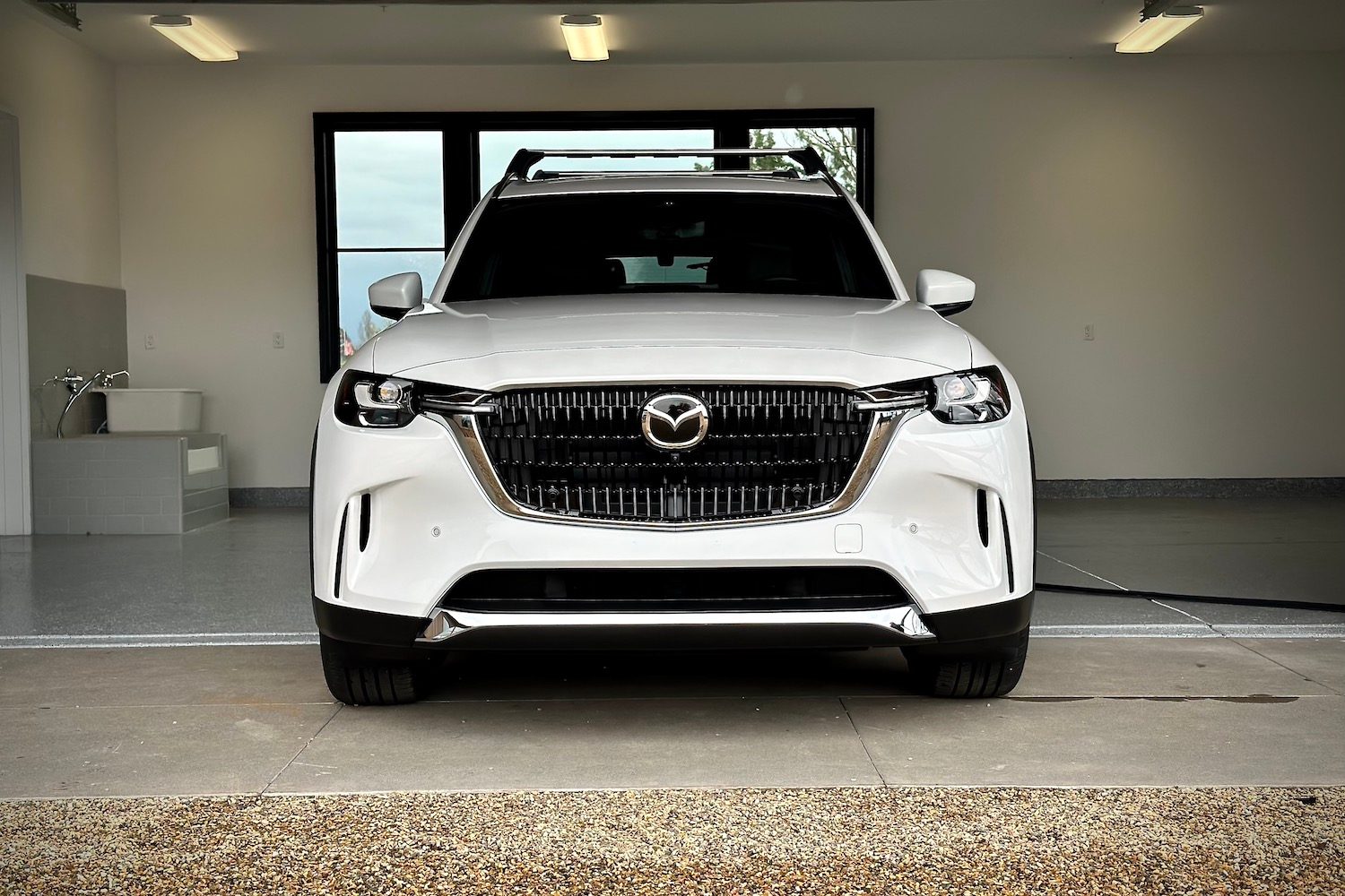 Front end close up of the 2024 Mazda CX-90 PHEV parked in a garage.