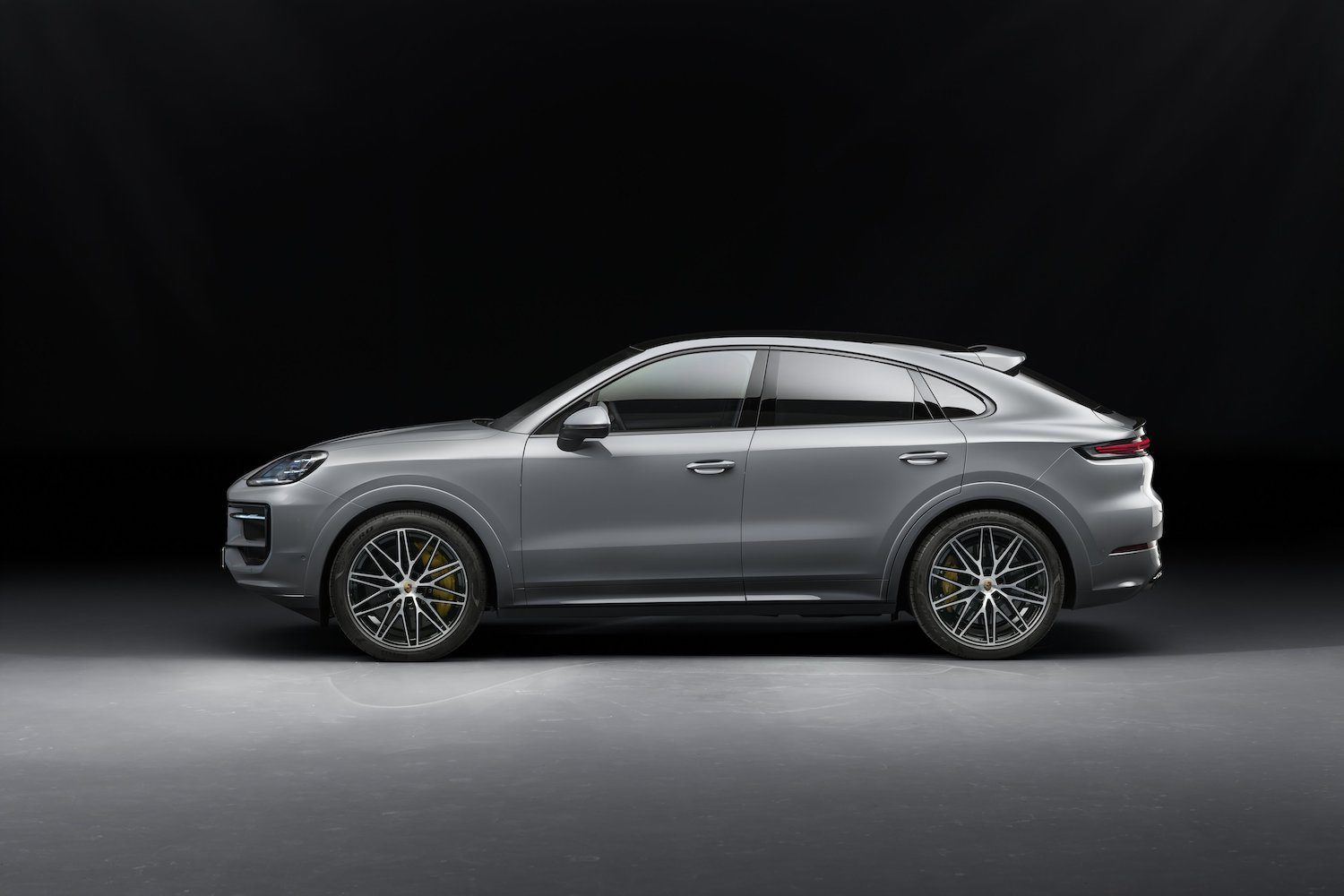 Side profile of the 2024 Porsche Cayenne S parked in a dark studio.
