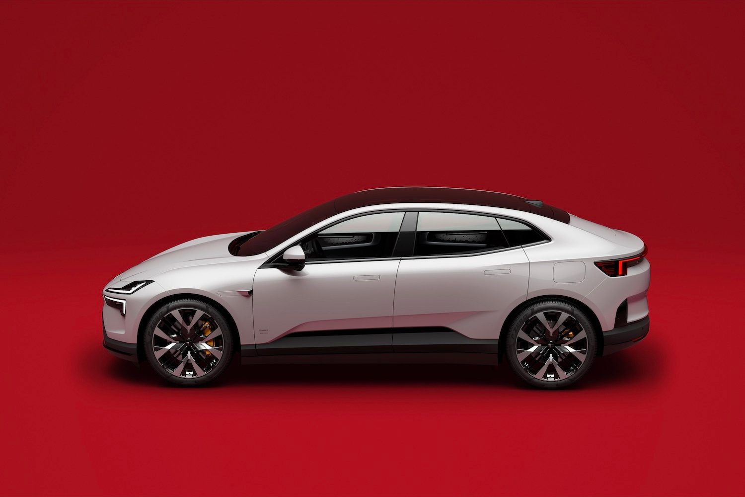 Side profile of the 2025 Polestar 4 parked in front of a red background.