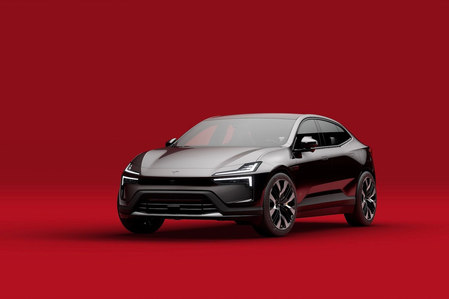 Front end angle of the 2025 Polestar 4 from the driver's side in front of a red background.
