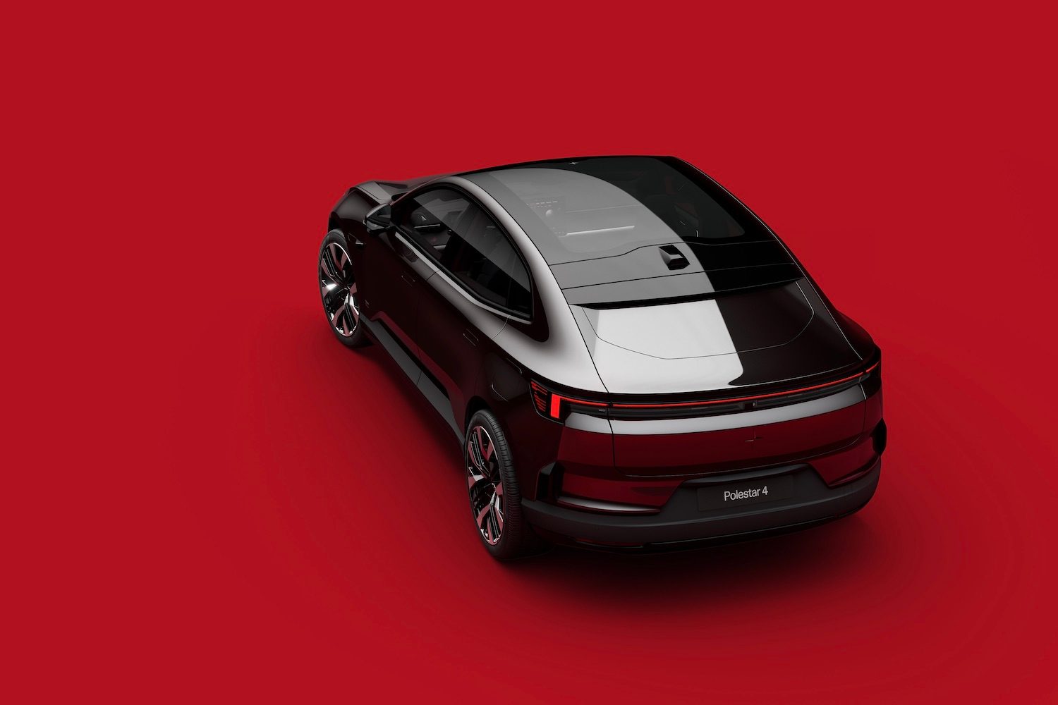Rear end angle of the 2025 Polestar 4 from overhead in front of a red background.