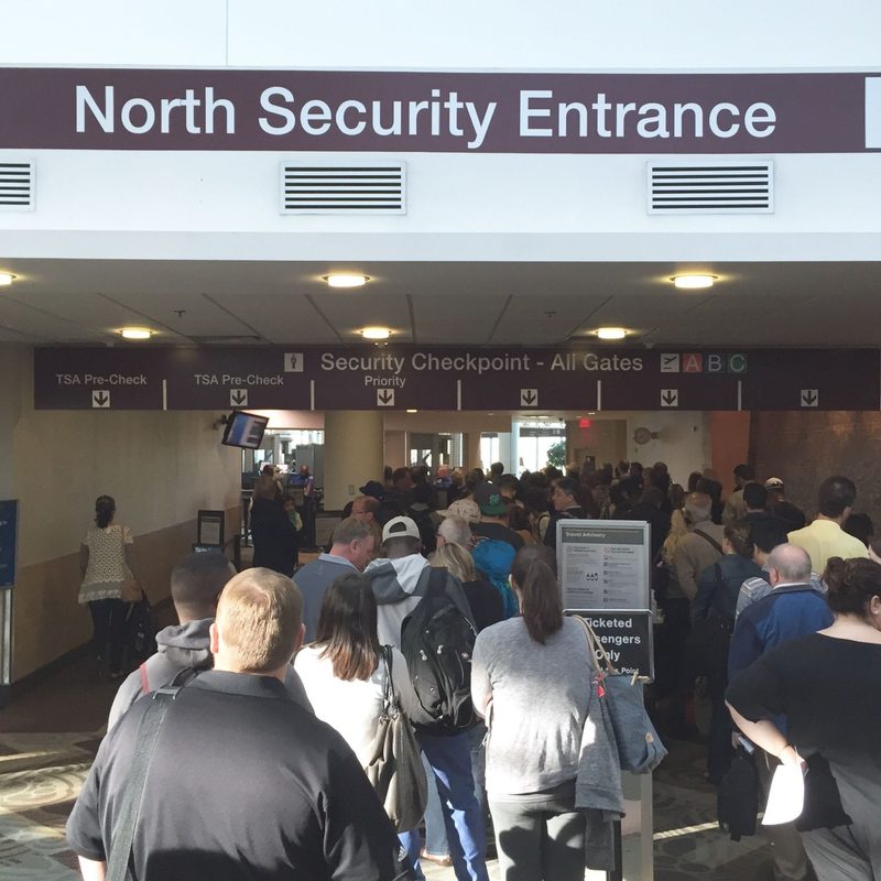 View of a very long airport security line from behind
