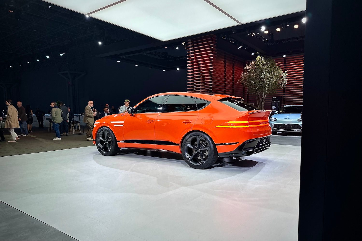 Rear end angle of the Genesis GV80 Coupe from the driver's side parked on a stage.