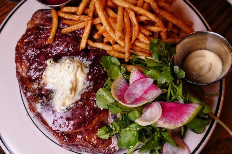 Steak frites on a plate.