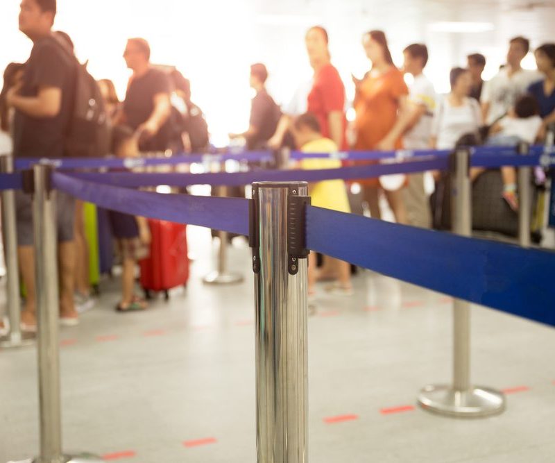 Airport security barriers with long line in background