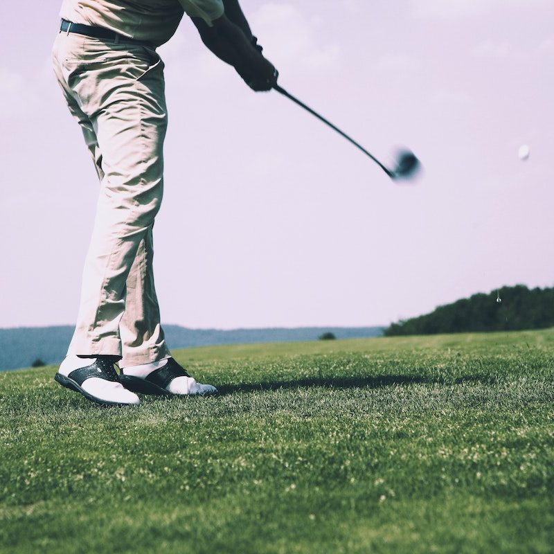 A person teeing off at a golf course