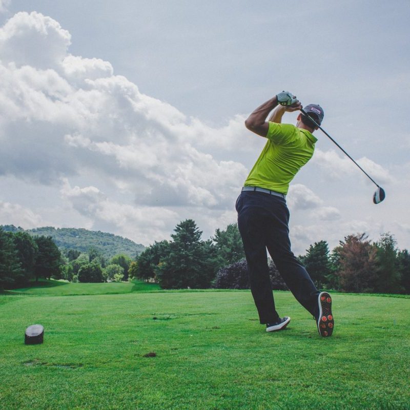 A person hitting a shot on the golf course